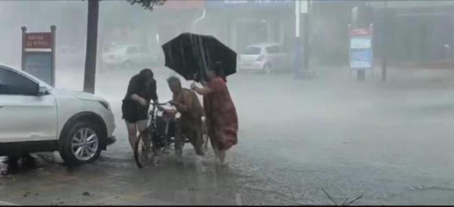 暴雨突降之际，英勇身影守护老人三轮车，温暖之心无畏前行。