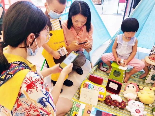 宝妈摆摊带娃套圈，顾客热情参与套娃活动体验